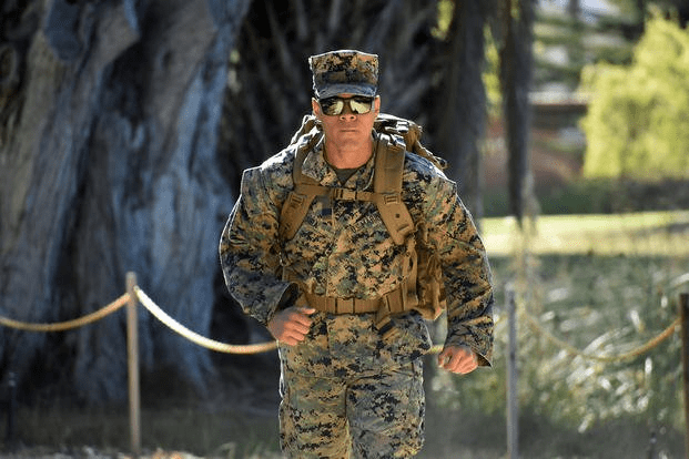 Army soldiers performing a ruck march during military training with weighted rucksacks